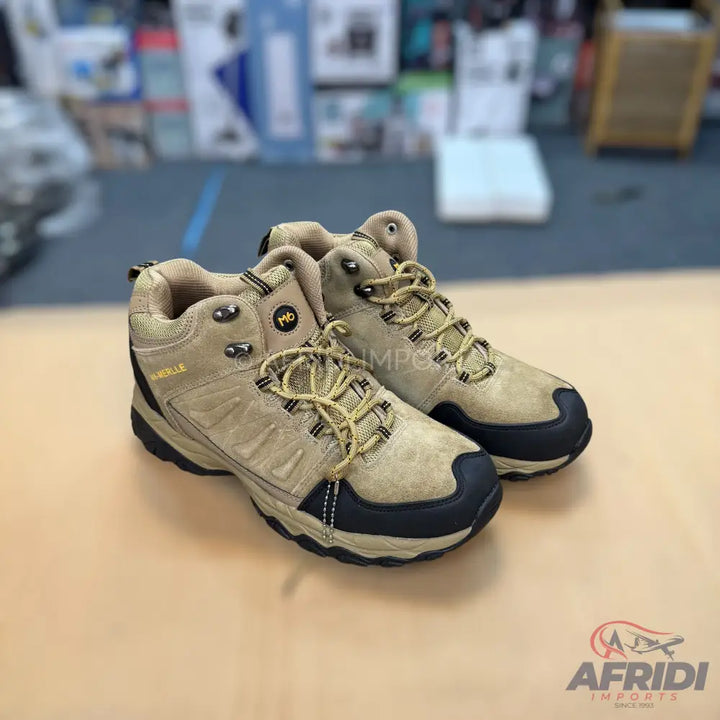 Pair of tan hiking boots with black soles and yellow laces