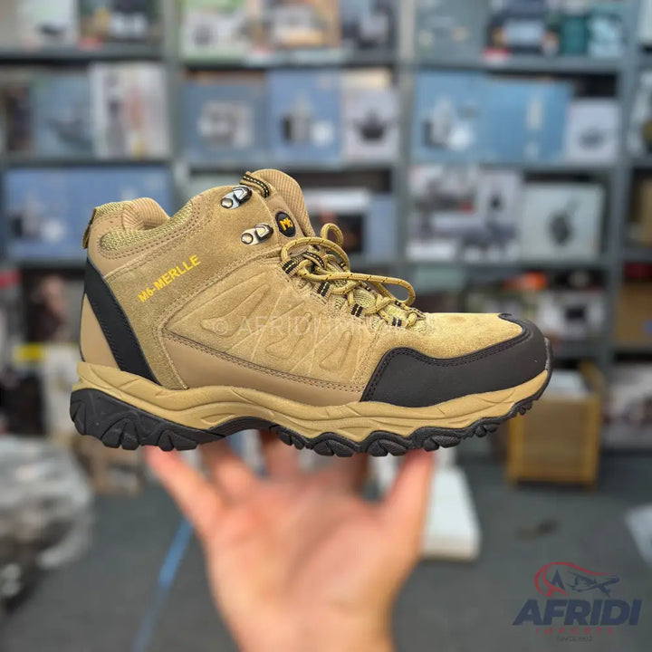A single tan and black hiking boot with yellow laces.