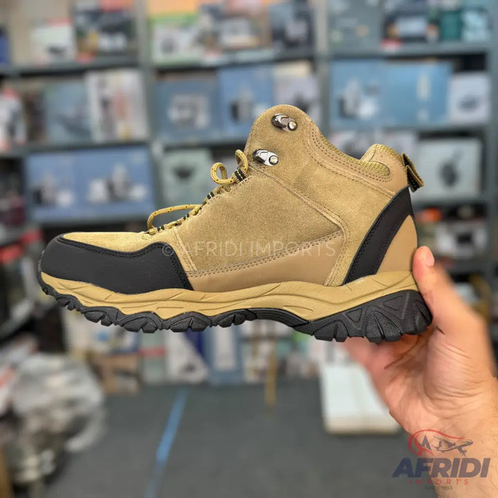 Tan and black men’s hiking boot with a rugged sole.