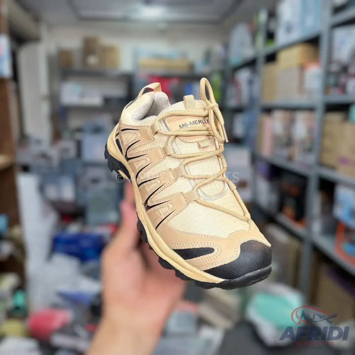 A tan and black hiking shoe with a textured sole.