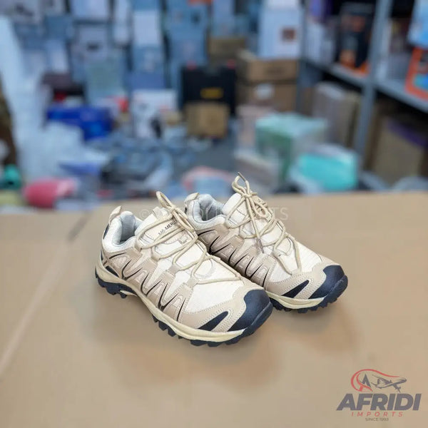 Pair of light brown hiking shoes with dark blue accents.