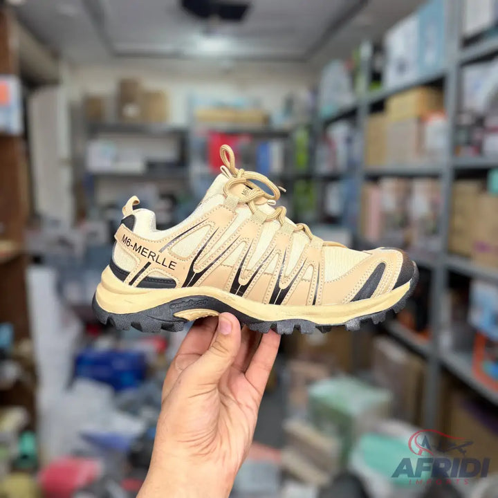 A single tan and black hiking shoe with a rugged sole.