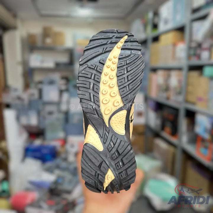 Rugged black and yellow athletic shoe sole with deep treads.