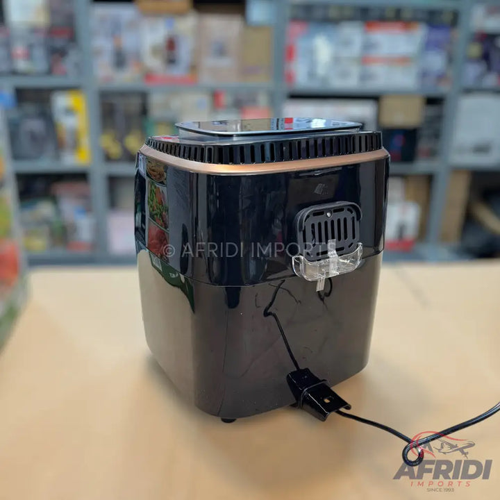 A compact, black air fryer with copper accents and a visible power cord.