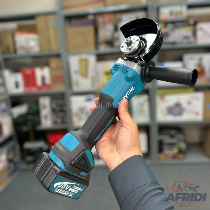 A teal and black cordless angle grinder with an attached battery pack.