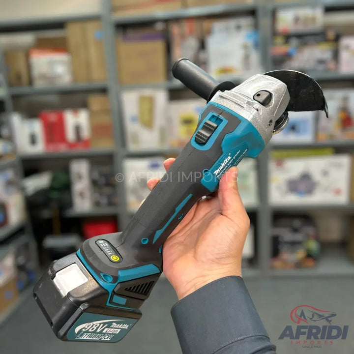A cordless angle grinder with a teal and black body, featuring a battery pack at the base.