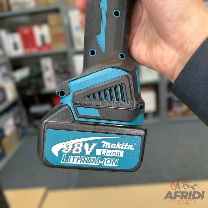 Hand holding a teal and black cordless power tool with a battery pack.