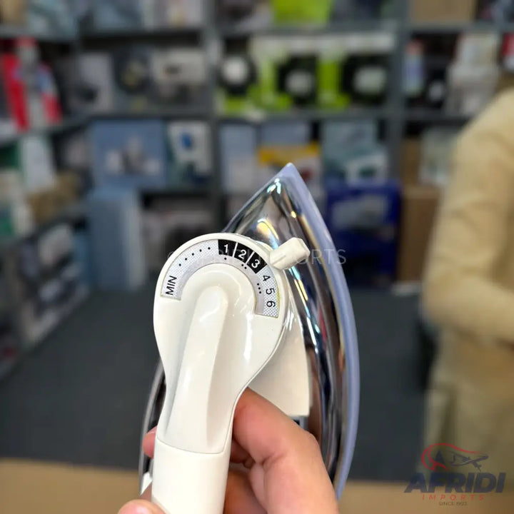 A white and chrome electric iron with a numbered temperature dial.