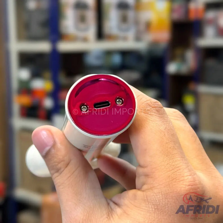 A handheld white and pink grooming device with a USB-C charging port.