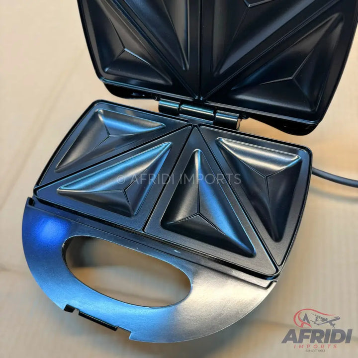 Open black sandwich maker with four triangular compartments.