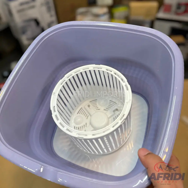 A portable, light purple, manual washing machine with a white inner basket.