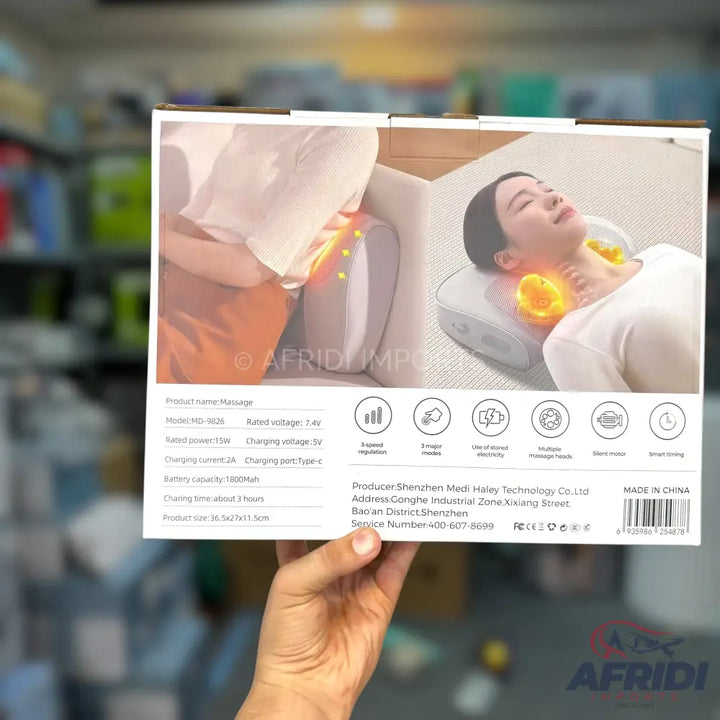 A person holding a product box for a cervical and lumbar massage pillow.