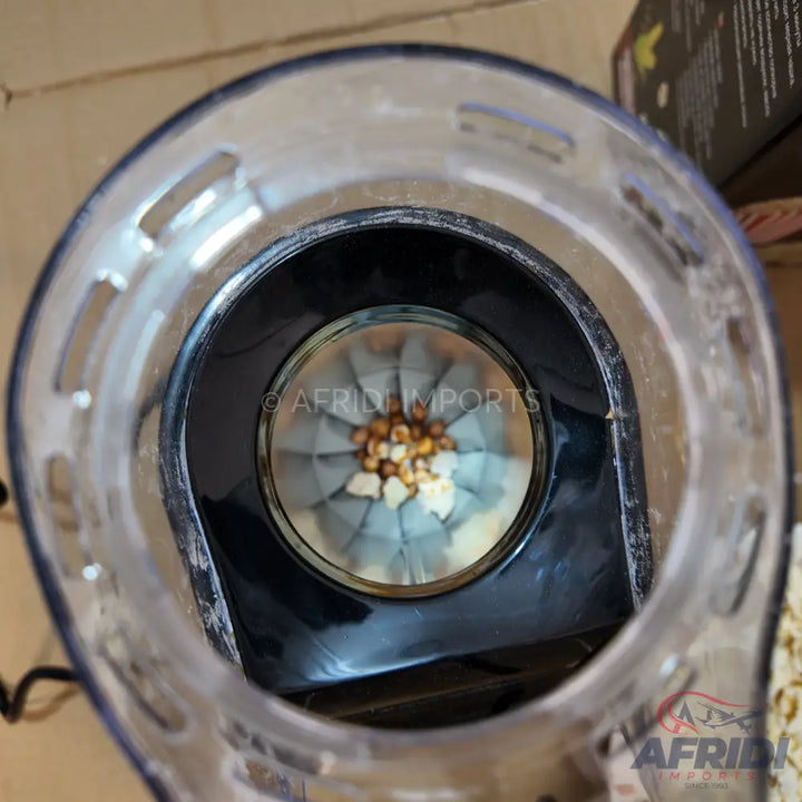 A popcorn machine with unpopped kernels and some already popped, ready for use.