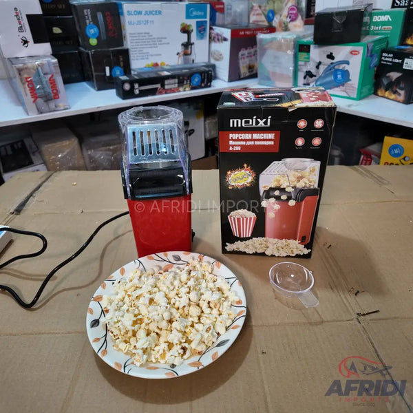 Red and black hot air popcorn maker with a transparent lid.