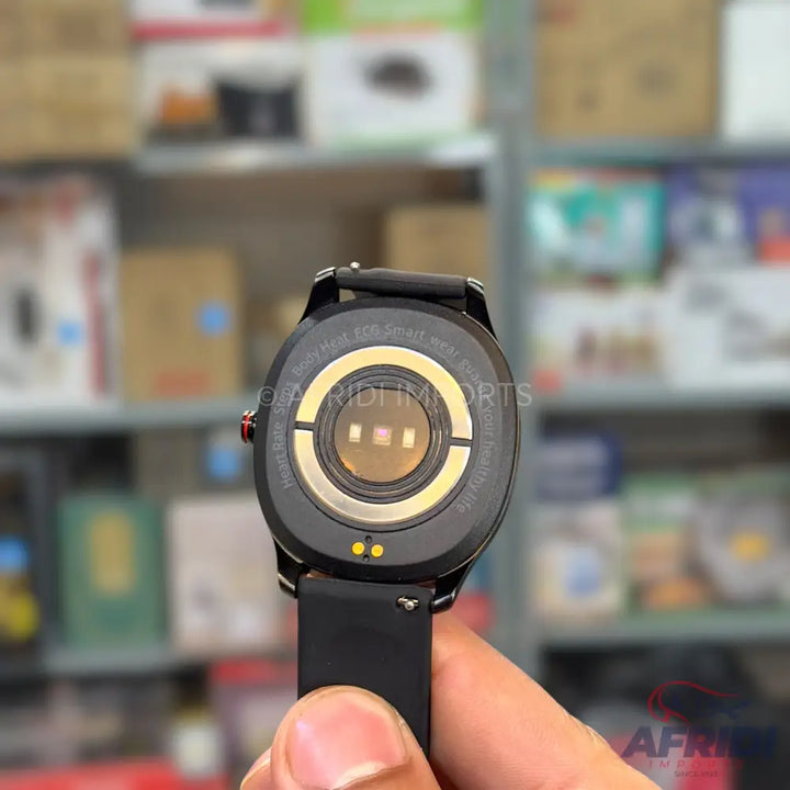 The back of a black smartwatch with a heart rate sensor and charging pins.