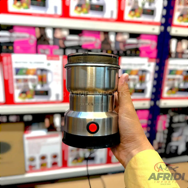 A stainless steel electric spice and coffee grinder with a single red power button.