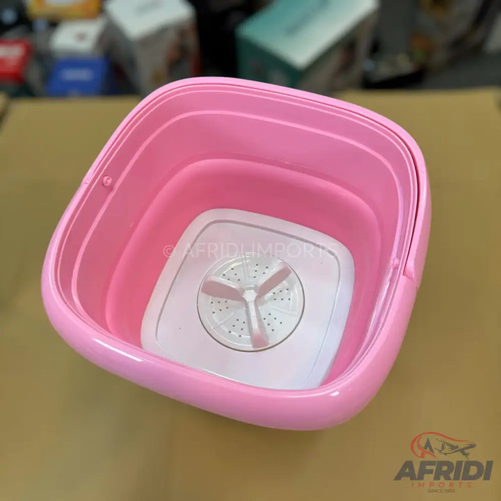 Pink collapsible portable washing machine with an agitator.