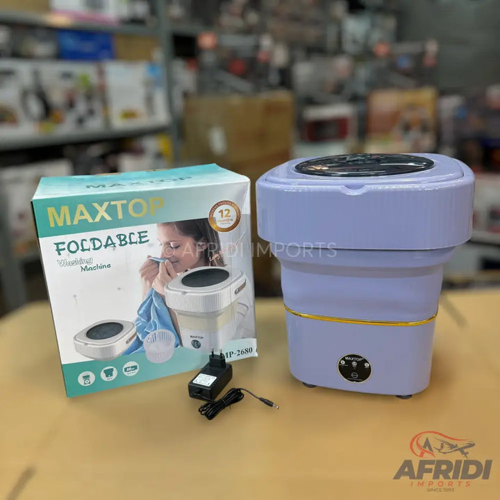 A foldable, portable washing machine, light purple with gold accents, and its packaging.