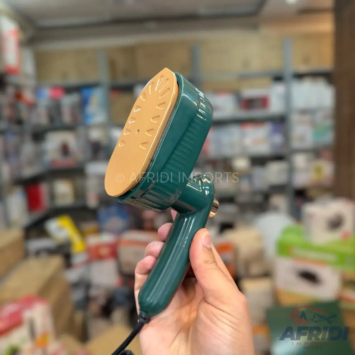 Green handheld steam iron with a tan soleplate.