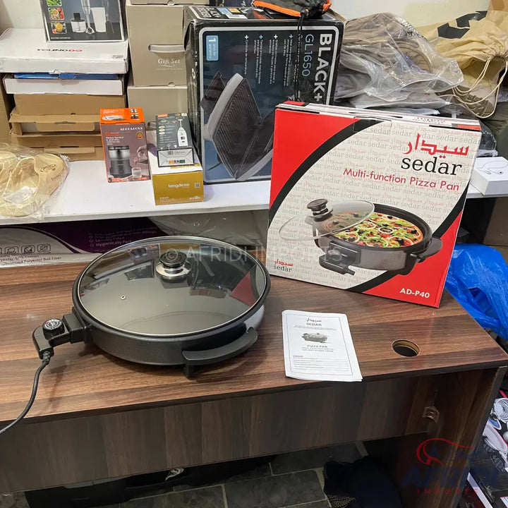 Electric multi-function pizza pan with a glass lid.