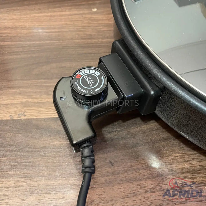 A black electric skillet temperature control probe with a dial thermostat for self-control, featuring multiple heat settings and a power cord.