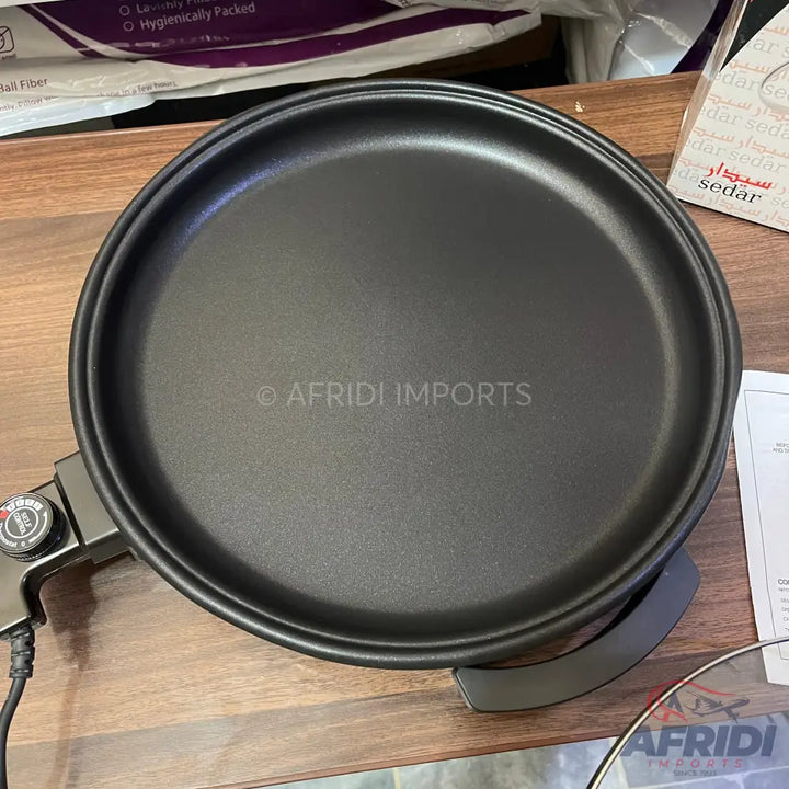 Black non-stick electric crepe maker with temperature control.
