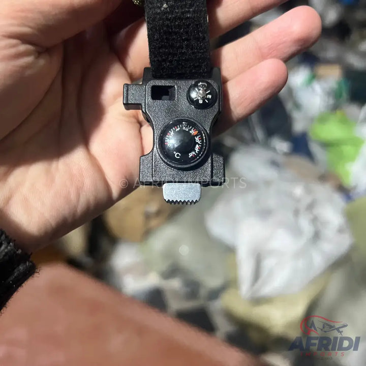Black plastic wristband buckle with an embedded compass and thermometer.
