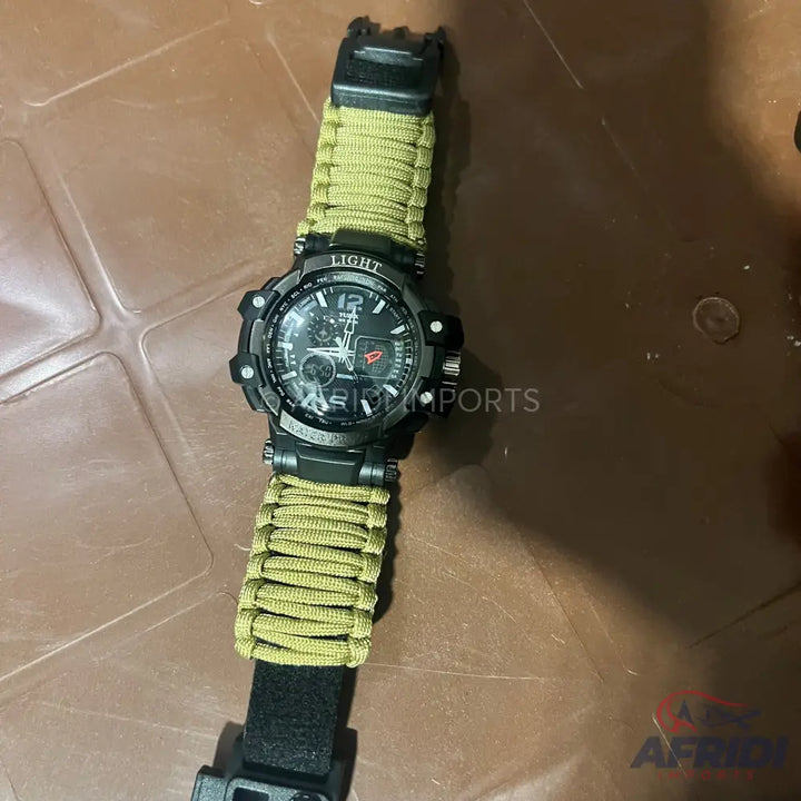 A black digital and analog wristwatch with a green paracord strap.