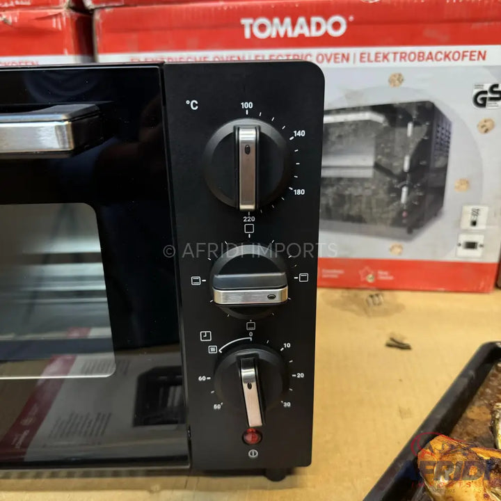 Black electric oven with three control knobs for temperature, heating element selection, and timer.