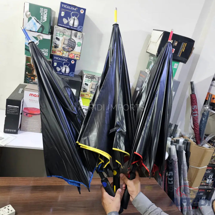 Three black umbrellas with colorful tips and inner linings.