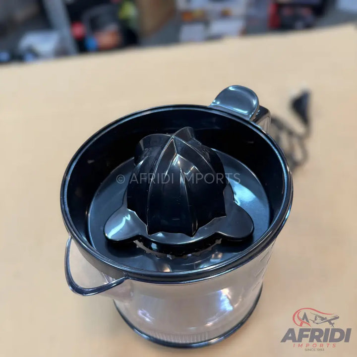 Black manual citrus juicer with a clear collection cup.