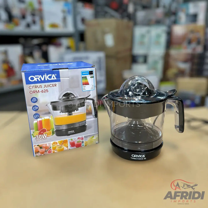 A black and clear electric citrus juicer with its packaging.