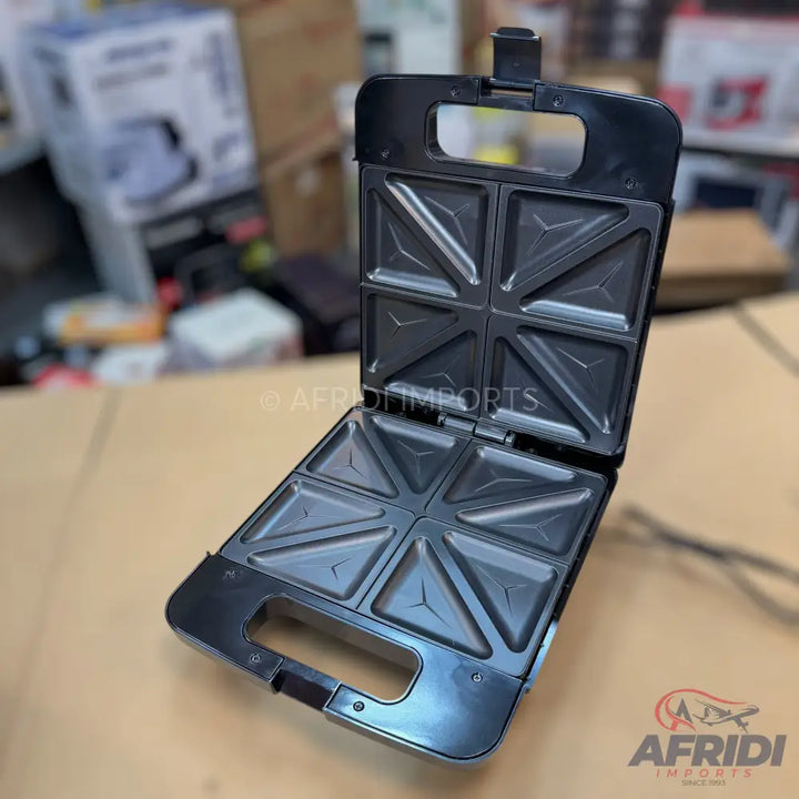 Black sandwich maker with four triangular compartments.