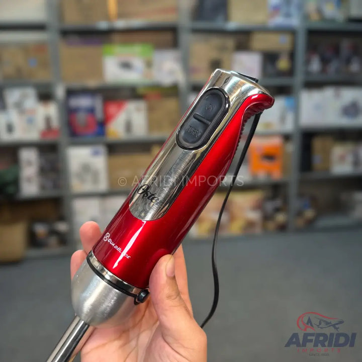 Red and silver immersion blender with two control buttons.