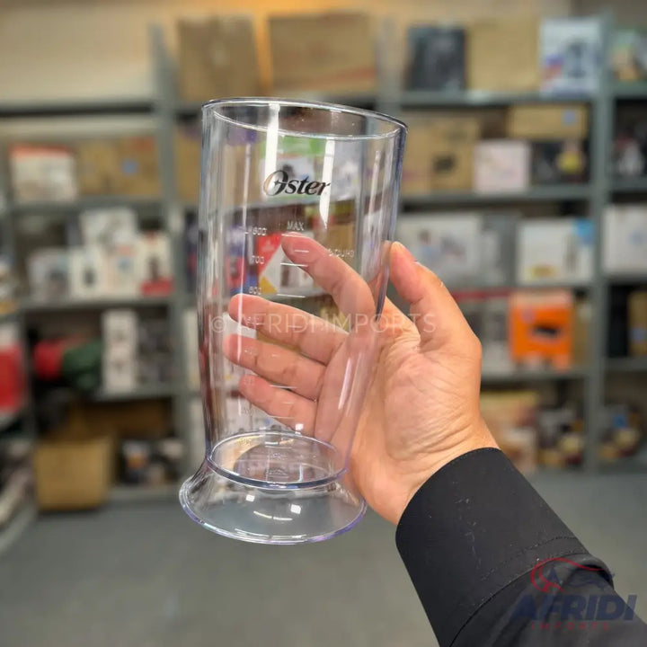 A clear plastic blender cup with measurement markings.
