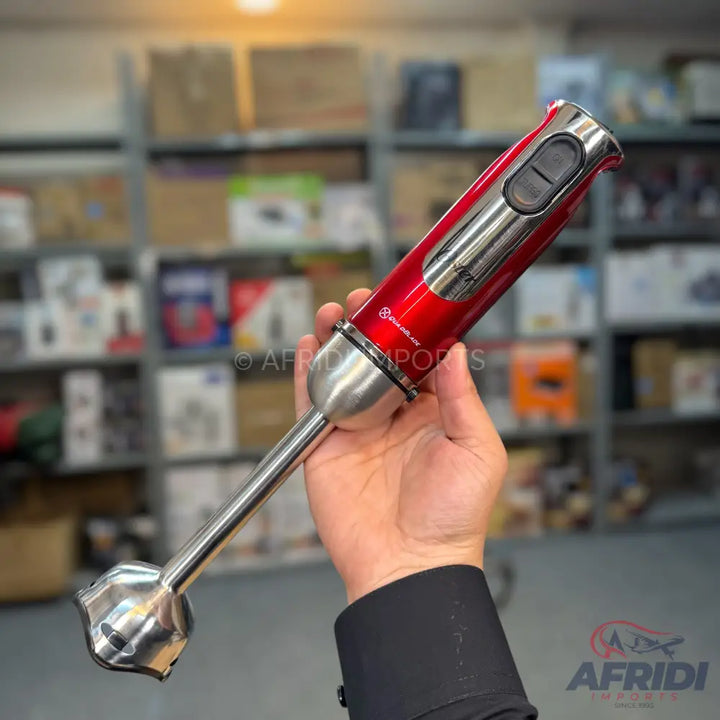 Red and silver immersion blender with a single speed button.