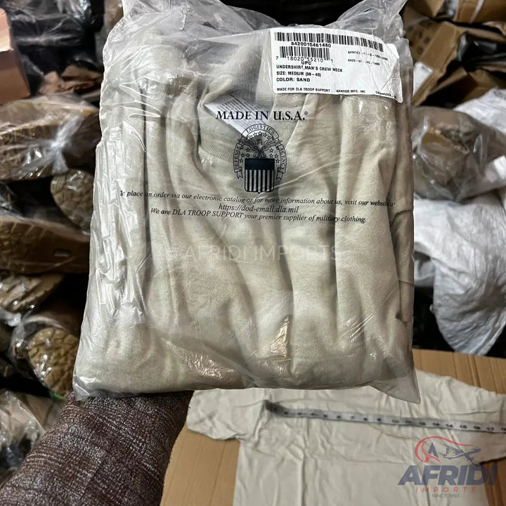 A packaged sand-colored crew neck undershirt.