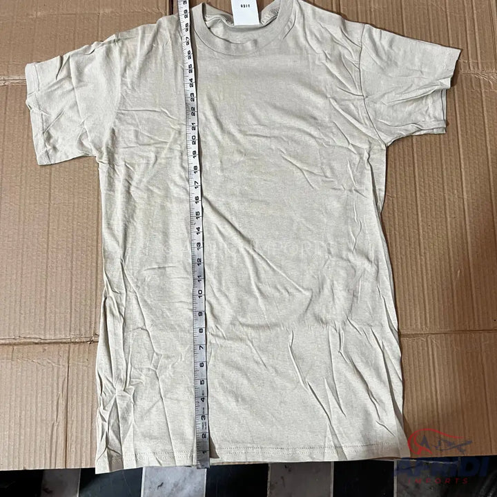 Light-colored short-sleeved t-shirt with a measuring tape laid over it.