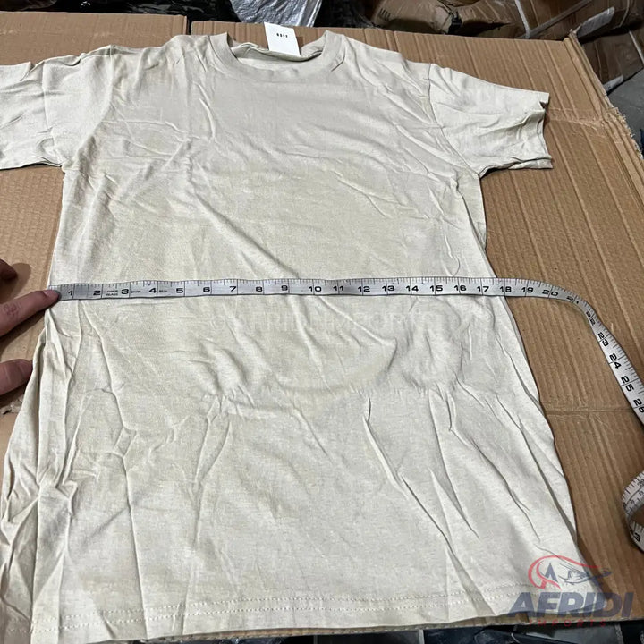 Light-colored, short-sleeved t-shirt with a measuring tape across its width.