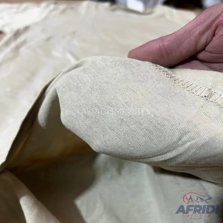 Close-up of a cream-colored textile with visible stitching and subtle texture variations.