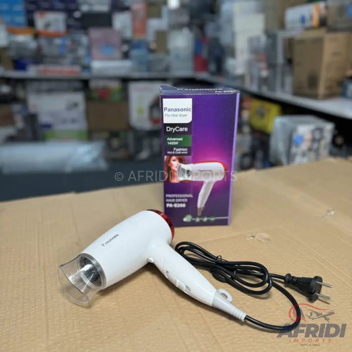 White and red hairdryer with a black power cord and a purple box.
