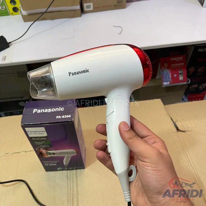White and red Panasonic hair dryer with a narrow nozzle and a hanging loop on the cord.