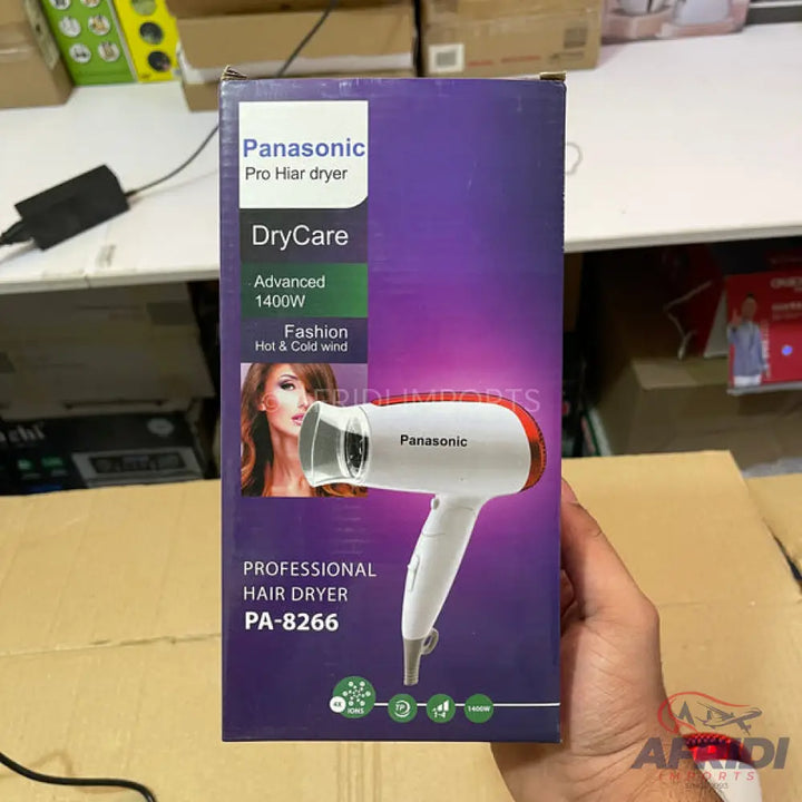 A white and red Panasonic hair dryer in its packaging, with features like ’DryCare,’ ’Advanced 1400W,’ ’Fashion Hot & Cold wind,’ and model number PA-8266.