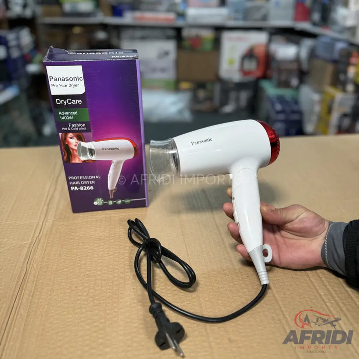 A white Panasonic hair dryer with a red rear grille and a black power cord.