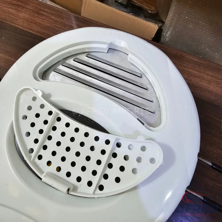 White plastic mandoline slicer with interchangeable blades and a grater attachment.