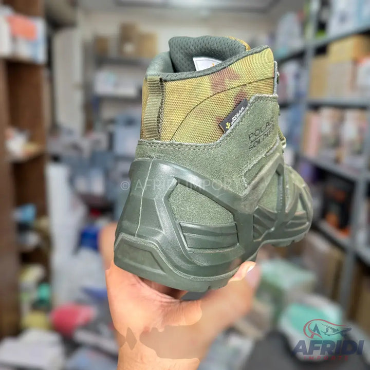A single olive green and camouflage hiking boot.