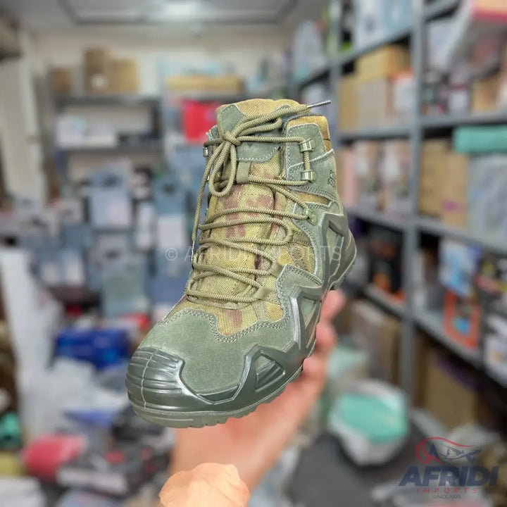 A single olive green and camouflage patterned hiking boot with textured soles and a lace-up closure.