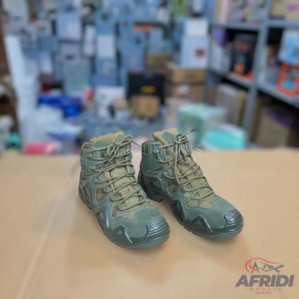 A pair of olive green, lace-up tactical or hiking boots.