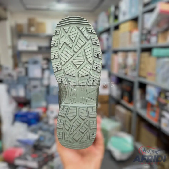 The sole of a light green or grey boot with a textured, anti-slip tread.