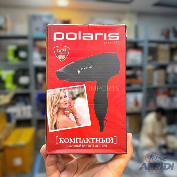 A red box for a Polaris hair dryer, featuring a compact design and a model using the product.